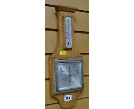 A vintage light oak barometer / thermometer