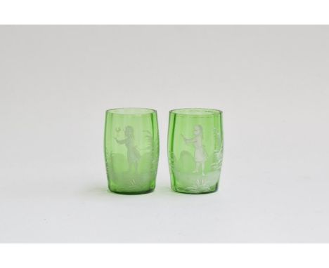 A pair of Mary Gregory style green glass tumblers, each decorated with white enamel depicting a young girl with a handful of 