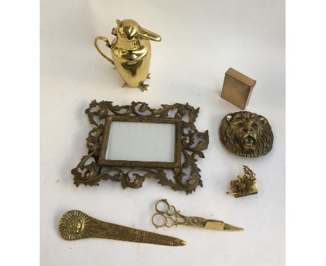 An mixed lot of brass items including Art Deco compact; heavy brass picture frame; bird character jug; lion belt buckle; cand