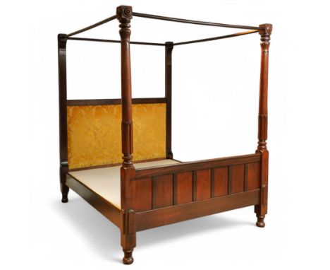 19th-century, mahogany four-poster bed with canopy frame, the headboard upholstered in a rich gold damask fabric, and footboa