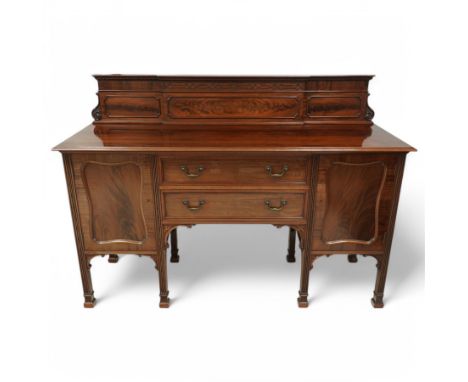 Early 20th century mahogany sideboard, raised figured back decorated with blind fretwork and scroll carved corner brackets, m