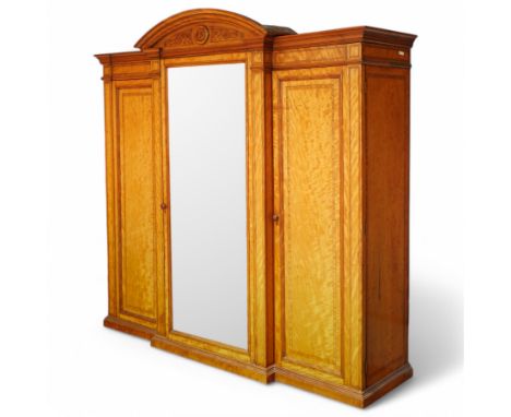 Victorian neoclassical style satinwood triple-section wardrobe, the central mirror section and arched pediment with carved mo