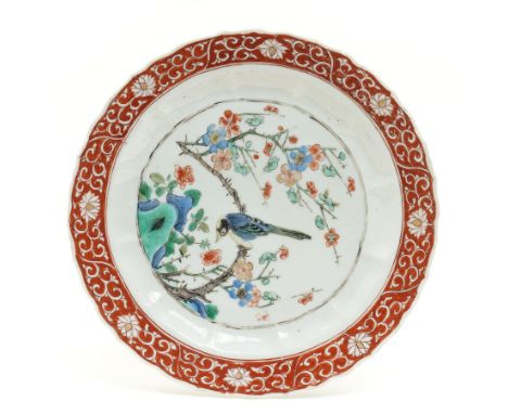 Chinese Kangxi famille verte plate, decorated with a bird perched upon a blossoming branch, within an iron red foliate border