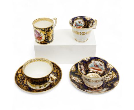 Early 19th century Derby trio of teacup, coffee can and saucer painted with a panel of  flowers within a dark blue and gilt s