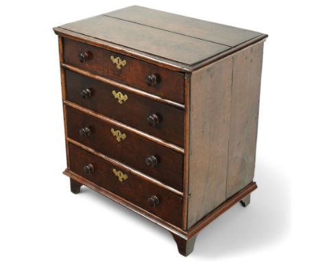 Small 18th century oak chest, two plank top with applied moulding, fitted with four long drawers, shaped and engraved brass e