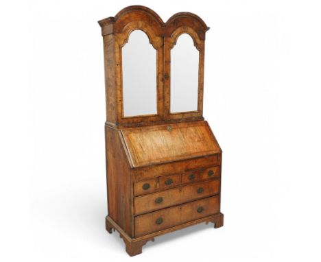 Early 18th century figured walnut dome top bookcase on bureau, double arch top over two bevelled mirror glazed doors, enclosi