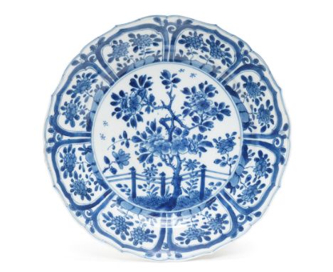 18th century Chinese Kangxi period blue and white plate, decorated with blossoming tree and fence inside a foliate border, D2
