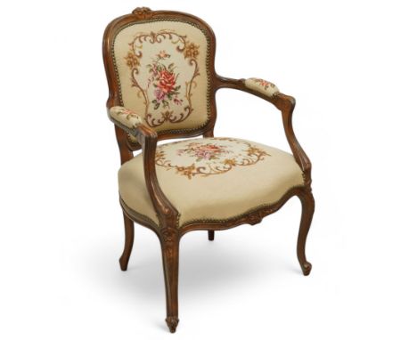 Early 20th century French walnut open armchair, carved top rail centred with floral cresting over a shaped back and serpentin