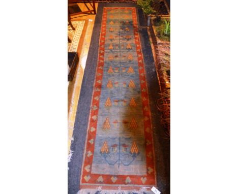 An Ushak runner, with vine decoration over faded blue ground and red leaf border, 320 x 65cm