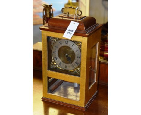 An English mahogany and gilt cased mantle clock, mounted by loop handle over glazed trunk, applied chapter ring, Roman numera