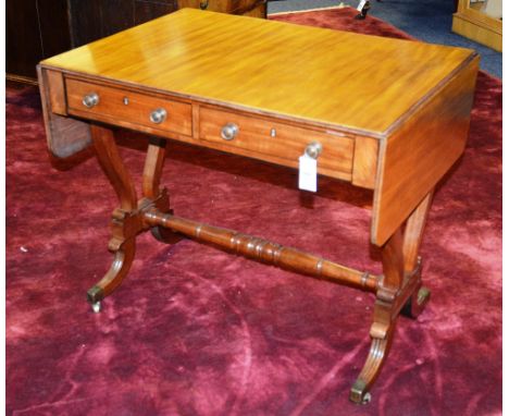 A Regency style mahogany sofa table, the reeded rectangular top with drop ends, over short frieze drawers and opposing dummy 