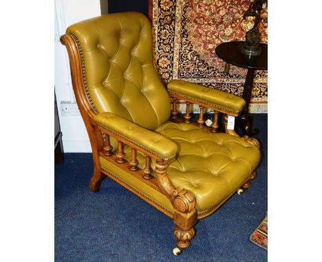 A Victorian mahogany and olive leather buttonback armchair, the scroll cushion back on moulded supports, cushioned arms on fl