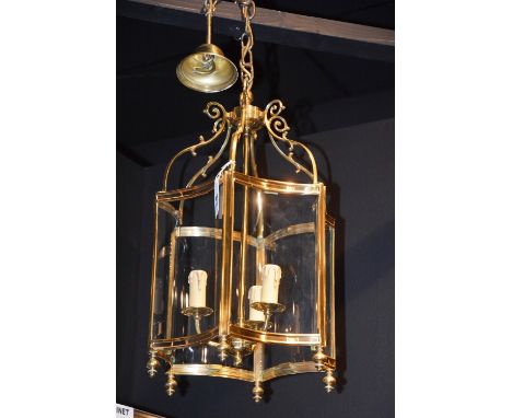 A pair of hexagonal ceiling lanterns, each with scrolling branches, concave glass panels surmounted by turned finials, enclos