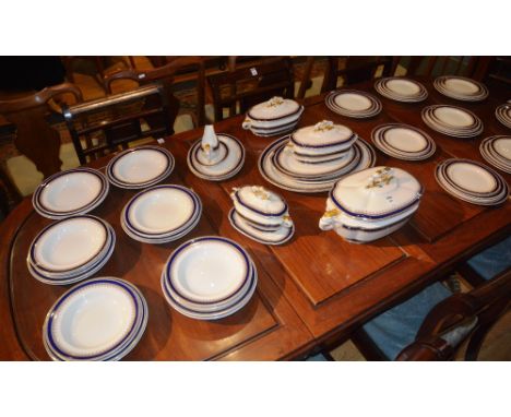 A Royal Worcester Pottery dinner set, decorated with gilt floral and blue border on white ground, brown stamp to base (67)