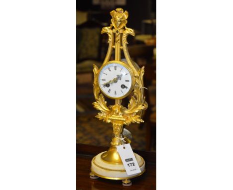 A French gilt metal mantle clock, with mask finial on hoho bird support, white enamelled face, Roman numerals, on acanthus br