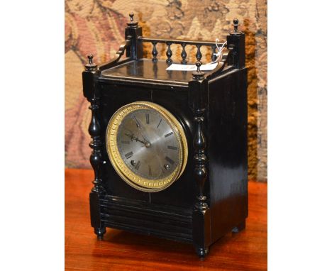 A black cased mantle clock, the three quarter gallery over brush metal circular face with Roman numerals, flanked by baluster
