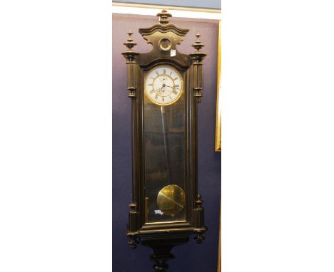 A Vienna wall clock, with ebonised case, glazed door enclosing an enamel dial with subsidiary seconds dial, single brass weig