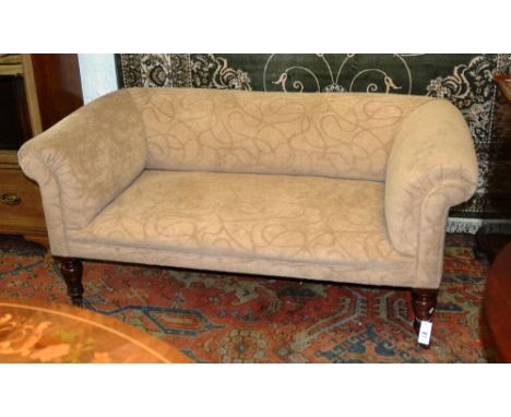 A late 19th century mahogany two seater Chesterfield, the cushioned back and seat raised on baluster turned legs terminating 