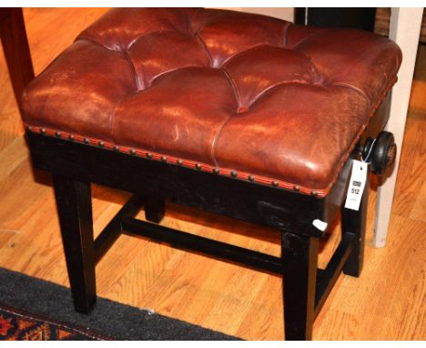 An adjustable piano stool, the rectangular button cushioned seat, raised on square tapering legs with turned handles, 56cm wi
