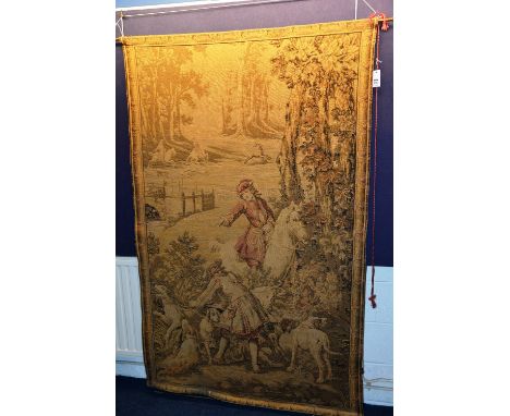 A Flemish style wall hanging tapestry, depicting a man on horseback with figures and dogs, 191cm long