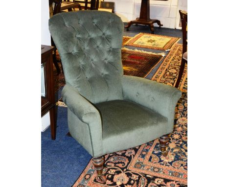 A Victorian button back armchair, with shaped back, scroll arms, sprung seat, raised on tapering turned legs terminating in b