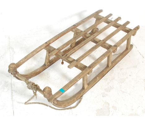 A vintage 20th Century wooden framed sleigh / sled having a rustic slated frame with with original pull rope. 27cm x 44cm x 1