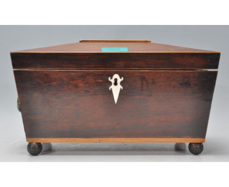 A 19th Century tea caddy of sarcophagus form having inlaid decoration and a mother of pearl shaped scutcheon to the front, ra