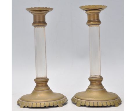 A pair of 19th Century antique brass candlestick having round bases with reeded rims, having faceted cut glass stem with bras