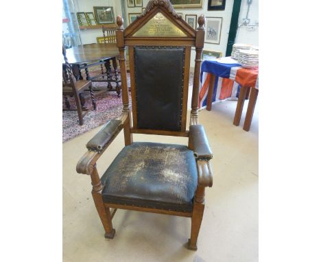 Heavy carved Oak framed Lodge chair with leather arms and seat padded with horse hair. Brass triangular plaque at the head of