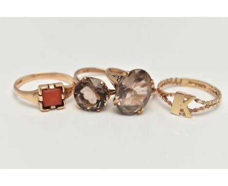 FOUR 9CT GOLD RINGS, to include a coral set signet ring, two smoky quartz set rings, and an initial K ring with a rope twist 