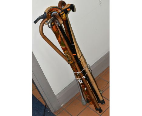 A GROUP OF ELEVEN WALKING STICKS, comprising a right handed stick with a handle for arthritis sufferer, silverplate handle, a