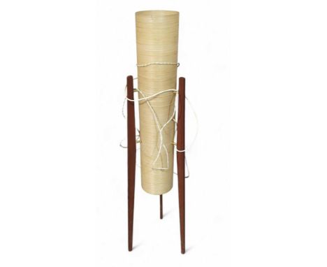 A mid-century rocket lamp on three extruding teak legs. The shade being a buff cylinder of woven texture. 113cm tall