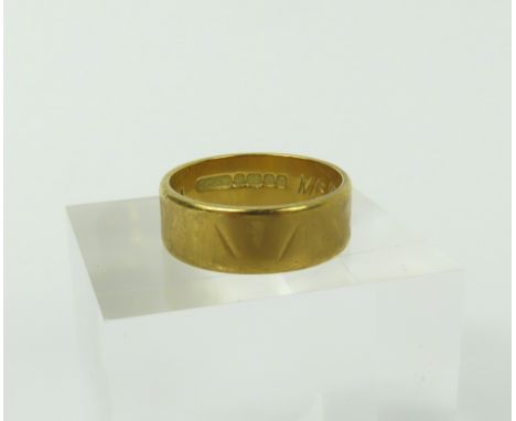 An 18ct gold wide wedding band, with worn pattern, finger size K leading edge, 4.88g gross