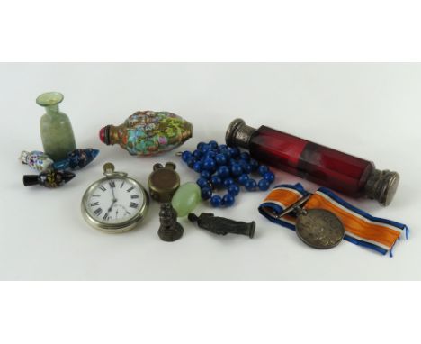 A collection of curios, to include a string of lapis lazuli beads, an LMS pocket watch, a red glass scent bottle, a WWI Briti
