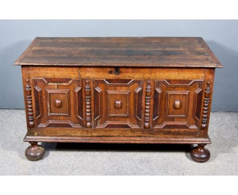 A 17th Century Panelled Oak Coffer, with moulded edge to top, three fielded panels to front, interspersed by split turned col