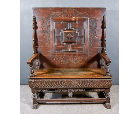 A 19th Century Oak Monks Bench, the three plank folding top with raised moulding and carved with fish, carved seat rail, on t