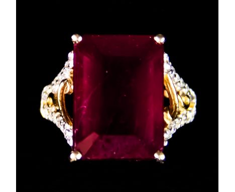 A 9ct Gold Ruby and Diamond Ring, Modern, set with a centre faceted ruby, approximately 9.4ct, surrounded by small brilliant 
