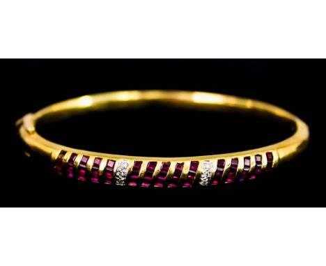 An 18ct Gold Ruby and Diamond Bangle, set with faceted ruby stones interspaced with small diamonds, 60mm diameter, gross weig
