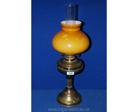A Brass oil Lamp with amber glass shade.