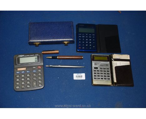 Two pens, one being a Parker ball point, a Casio 822 calculator, a Casio SL 1100TV calculator and an Aurora power calculator.