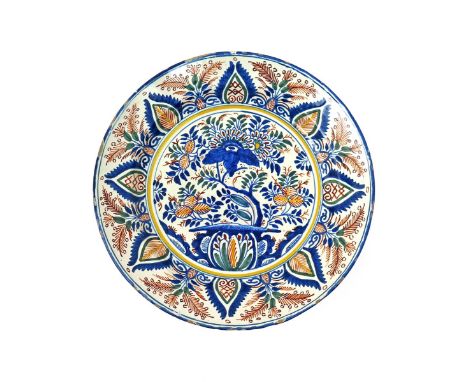 A large delftware polychrome charger  probably London c.1705, brightly decorated in a polychrome palette of red, yellow, blue