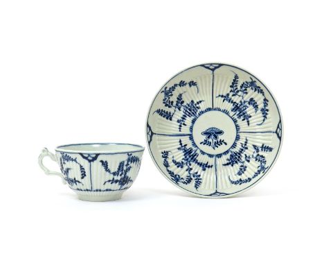 A Worcester blue and white teacup and saucer  c.1770, of generous reeded form, painted with the Immortelles pattern of sprawl