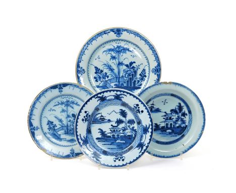 Three delftware plates  mid 18th century, two painted in blue with tall bamboo sprays beside flowering peony and rockwork, is