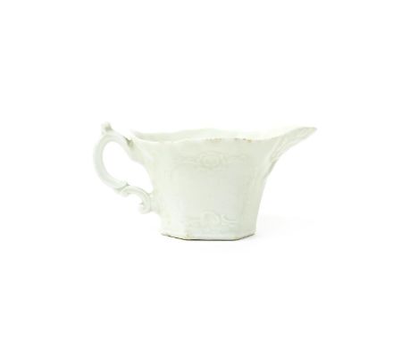 A Worcester white-glazed creamboat  c.1753-55, the hexagonal form moulded with scrollwork panels beneath a flared rim, with d