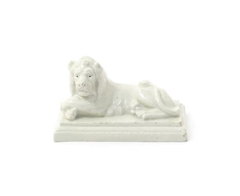 An unusual ceramic model of a recumbent lion  probably 18th century, laying on a stepped rectangular base with his front paws