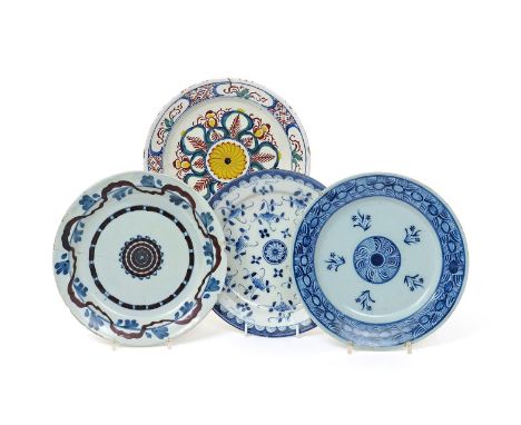 Four Delft and delftware plates  18th century, variously painted in blue and polychrome enamels with a central roundel within