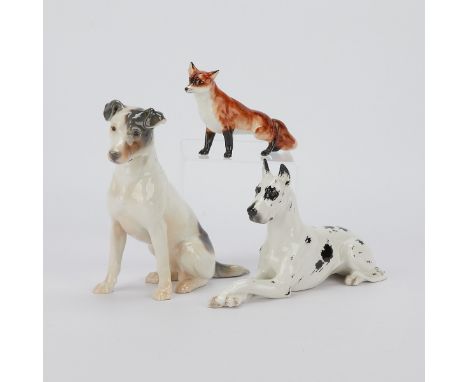 Group of three porcelain animals including:Boehm, United States. Porcelain fox and Harlequin Great Dane dog laying down with 