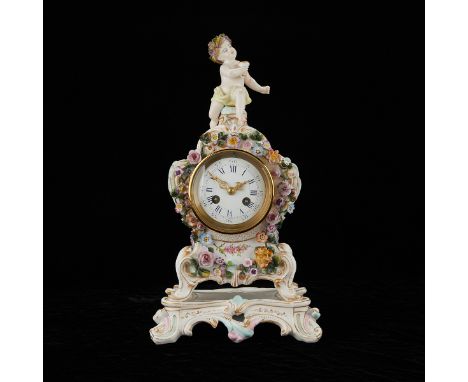 Dresden, Germany. Porcelain clock with applied flowers throughout and a cherubic baby finial. With gilded decorations through