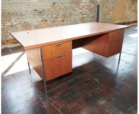 Dunbar, United States. Mid-century modern teak and walnut desk with chrome fittings. With five drawers, one with a lock. With