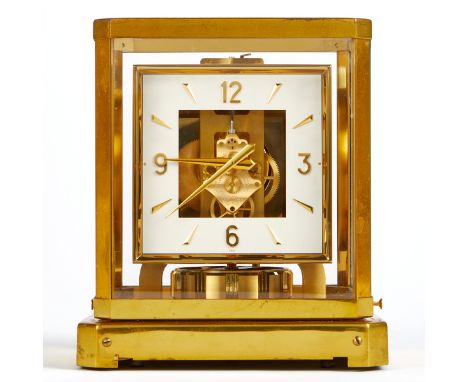 Jaeger LeCoultre, Switzerland. Atmos mantle clock. Square white enamel dial with gold Arabic and stroke numerals. In a glass 